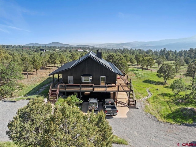 122 Juniper Rd, Ridgway, CO 81432 - chalet / cabin with stairs, a chimney, a deck with mountain view, and gravel driveway