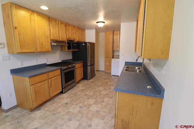 771 Aspen Dr, Cortez, CO 81321 - kitchen with appliances with stainless steel finishes, under cabinet range hood, washer / dryer, dark countertops, and recessed lighting