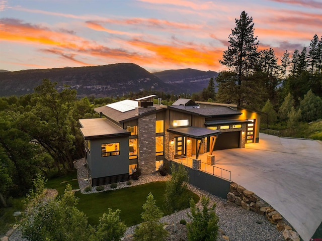 2161 Scout Ridge Rd, Durango, CO 81301 - contemporary home with concrete driveway, a mountain view, stone siding, a garage, and a yard