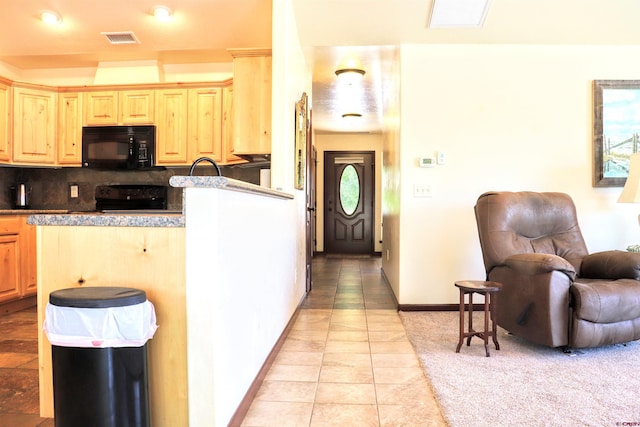 521 Alta Lakes Ave, Montrose, CO 81403 - kitchen with black microwave, stove, light brown cabinets, light tile patterned flooring, and decorative backsplash