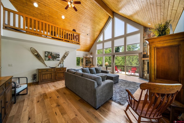 261 Aspen Dr, Durango, CO 81301 - living room featuring high vaulted ceiling, a wooden ceiling with exposed beams, light wood-style floors, a ceiling fan, and a stone fireplace