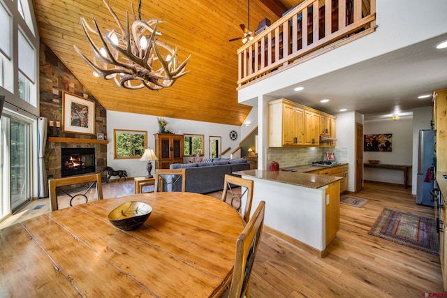 261 Aspen Dr, Durango, CO 81301 - dining space with high vaulted ceiling, a fireplace, light wood-type flooring, wooden ceiling, and a ceiling fan