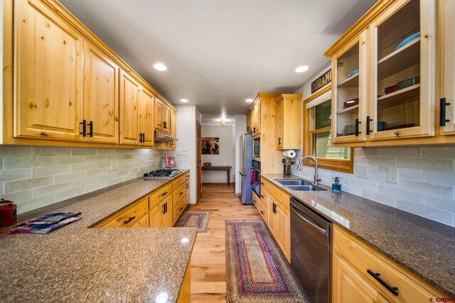 261 Aspen Dr, Durango, CO 81301 - kitchen featuring appliances with stainless steel finishes, light wood finished floors, decorative backsplash, recessed lighting, and glass insert cabinets
