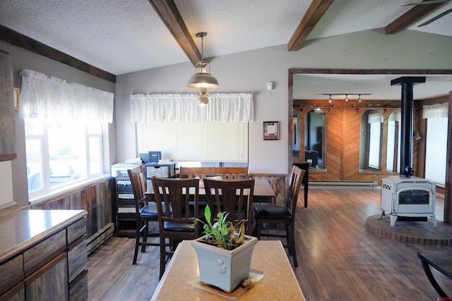 20657 Del Ray Dr, Eckert, CO 81418 - dining space with a wood stove, healthy amount of natural light, beamed ceiling, wood finished floors, and a textured ceiling