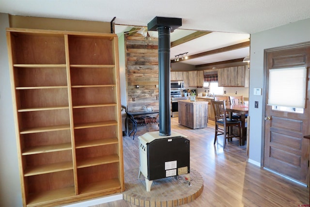 20657 Del Ray Dr, Eckert, CO 81418 - living room with a wood stove, light wood-type flooring, and beam ceiling