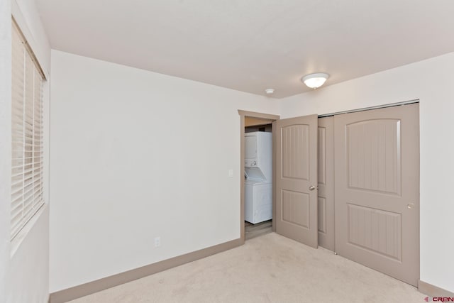 109 Anna Ct Unit 8B, Grand Junction, CO 81503 - unfurnished bedroom featuring stacked washer and clothes dryer, carpet floors, and a closet