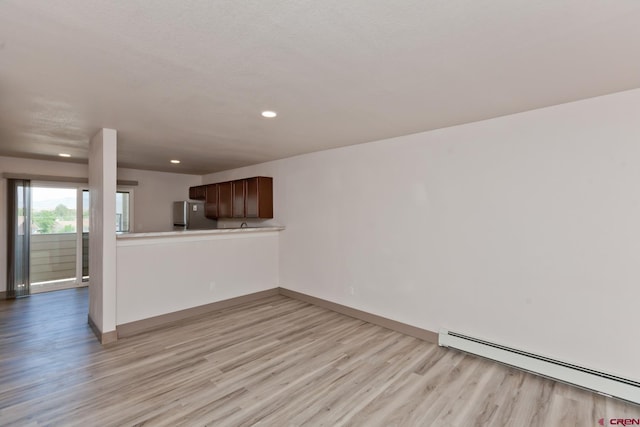 109 Anna Ct Unit 8B, Grand Junction, CO 81503 - unfurnished living room featuring a baseboard heating unit, light wood finished floors, and recessed lighting