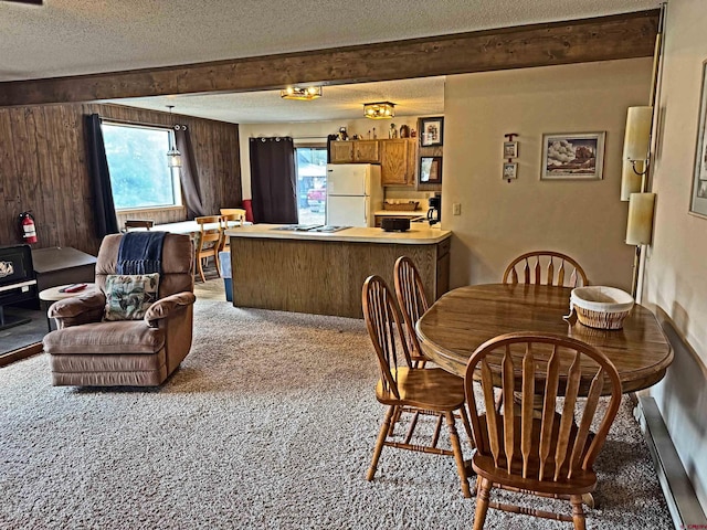 152 Conifer Dr, South Fork, CO 81154 - dining room featuring carpet, a textured ceiling, healthy amount of natural light, beam ceiling, and wooden walls