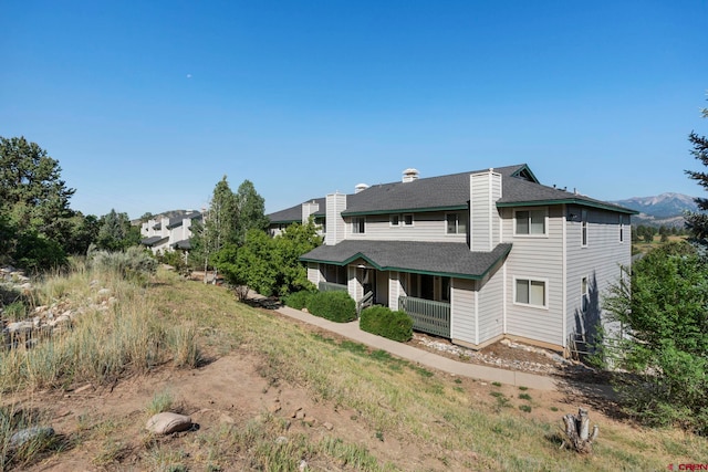 1100 Goeglein Gulch Rd Unit 171, Durango, CO 81301 - rear view of property with a chimney, a porch, and roof with shingles