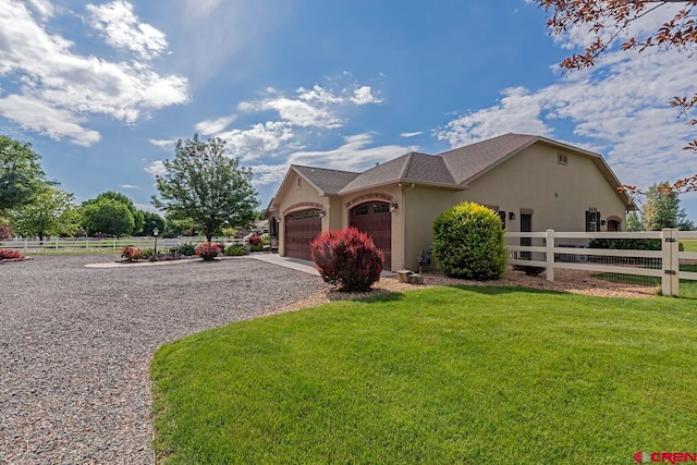 1734 Dry Creek Cir, Delta, CO 81416 - view of front of home with stucco siding, gravel driveway, and an attached garage