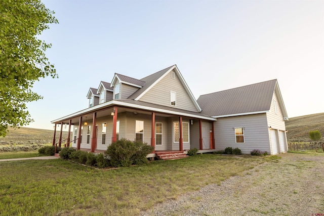 825 County Road 17, Gunnison, CO 81230 - country-style home with covered porch, an attached garage, a metal roof, driveway, and a front yard