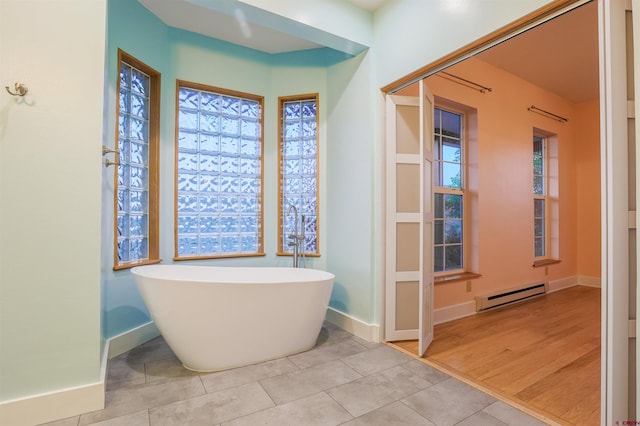 825 County Road 17, Gunnison, CO 81230 - full bathroom featuring baseboard heating, a freestanding bath, tile patterned flooring, and healthy amount of natural light