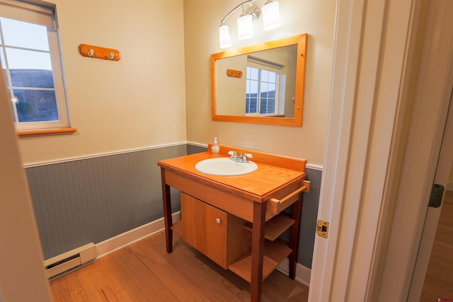 825 County Road 17, Gunnison, CO 81230 - bathroom with baseboard heating, wainscoting, wood finished floors, and vanity