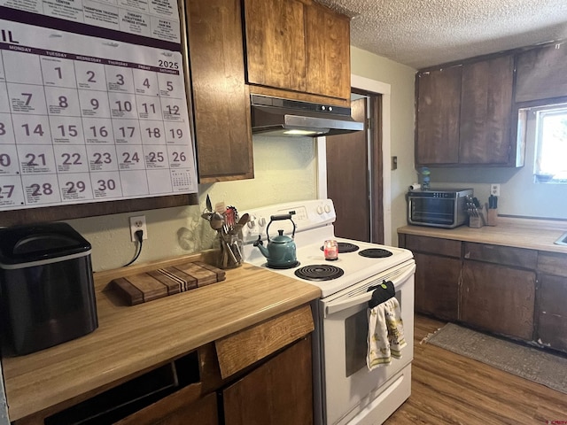537 N Colorado Ave, Dove Creek, CO 81324 - kitchen featuring under cabinet range hood, electric stove, a textured ceiling, light countertops, and dark wood-style flooring