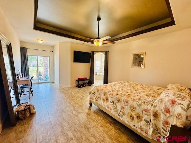 1490 SE Fairway Dr, Cedaredge, CO 81413 - bedroom featuring a raised ceiling, access to outside, arched walkways, and a ceiling fan