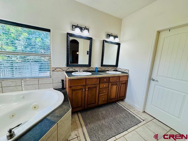 1490 SE Fairway Dr, Cedaredge, CO 81413 - bathroom with double vanity, a tub with jets, and tile patterned flooring