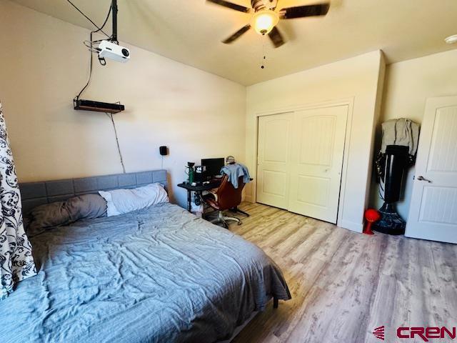 1490 SE Fairway Dr, Cedaredge, CO 81413 - bedroom featuring wood finished floors, a closet, and a ceiling fan