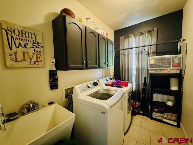 1490 SE Fairway Dr, Cedaredge, CO 81413 - laundry area featuring cabinet space, washing machine and dryer, and light tile patterned floors