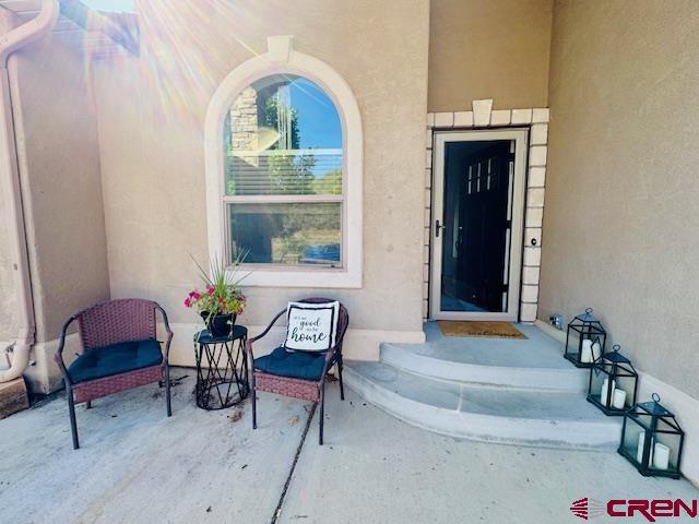 1490 SE Fairway Dr, Cedaredge, CO 81413 - entrance to property with stucco siding and a patio