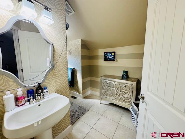 1490 SE Fairway Dr, Cedaredge, CO 81413 - bathroom with tile patterned flooring and vaulted ceiling