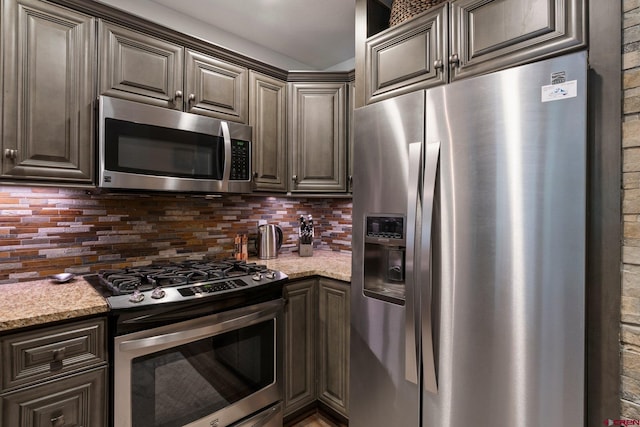 73 S Tamarron Dr Unit 822, Durango, CO 81301 - kitchen featuring appliances with stainless steel finishes, tasteful backsplash, light stone counters, and dark brown cabinetry