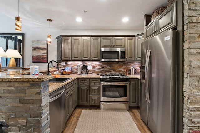 73 S Tamarron Dr Unit 822, Durango, CO 81301 - kitchen with stainless steel appliances, a peninsula, light stone countertops, and wood finished floors