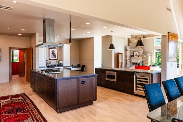 570 Jenkins Ranch Rd, Durango, CO 81301 - kitchen with island exhaust hood, beverage cooler, dark brown cabinetry, a kitchen island, and recessed lighting