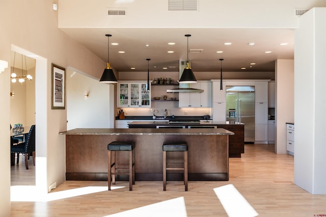 570 Jenkins Ranch Rd, Durango, CO 81301 - kitchen featuring extractor fan, built in fridge, light wood-style flooring, a peninsula, and dark countertops