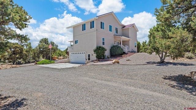 61850 V62 Trl, Montrose, CO 81403 - view of side of property with driveway, a garage, stucco siding, and a standing seam roof