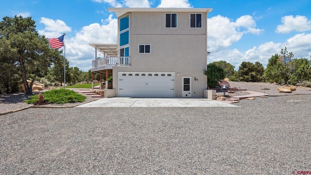 61850 V62 Trl, Montrose, CO 81403 - rear view of house with concrete driveway, stucco siding, an attached garage, and a balcony