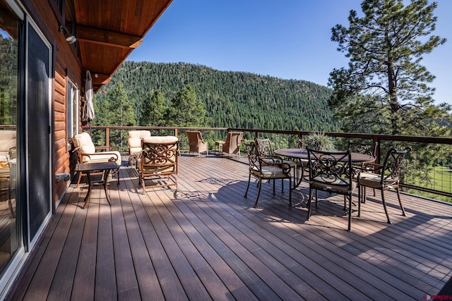 9 Los Ranchitos Dr, Durango, CO 81301 - wooden terrace featuring a view of trees, outdoor dining area, and a mountain view