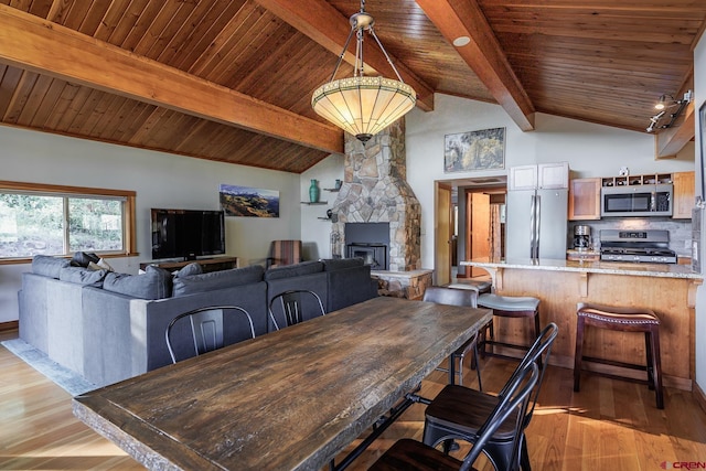 9 Los Ranchitos Dr, Durango, CO 81301 - dining room featuring wooden ceiling, light wood-style floors, and a stone fireplace