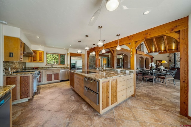 2415 Echo Canyon Ranch Ln, Pagosa Springs, CO 81147 - kitchen featuring stainless steel appliances, wall chimney range hood, a large island, a warming drawer, and decorative light fixtures