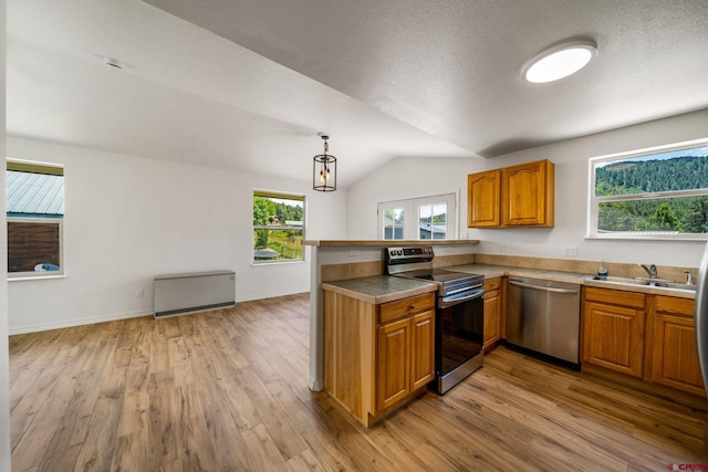 268 Forest Lakes Dr, Bayfield, CO 81122 - kitchen featuring stainless steel appliances, a peninsula, brown cabinets, light wood-style flooring, and lofted ceiling