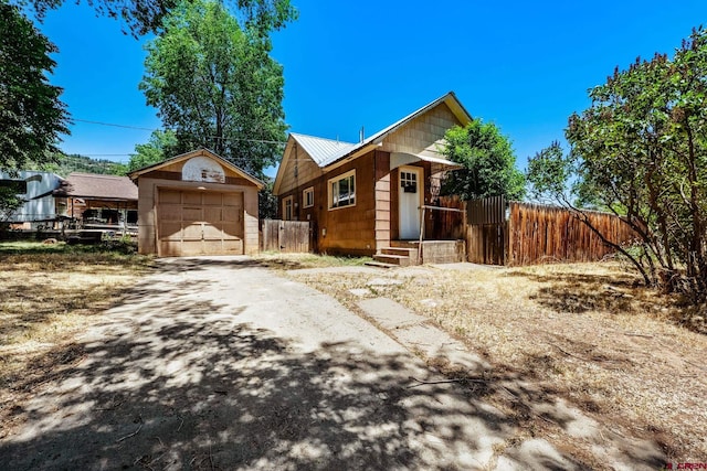 111 E 31st St, Durango, CO 81301 - view of front of house featuring a garage, driveway, an outdoor structure, and a metal roof