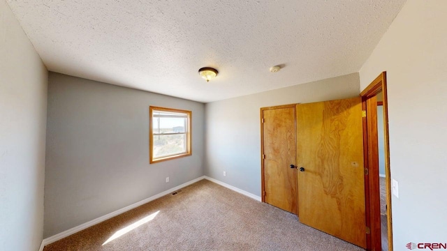 19029 Country Dr, Alamosa, CO 81101 - unfurnished bedroom with a textured ceiling, a closet, and carpet floors