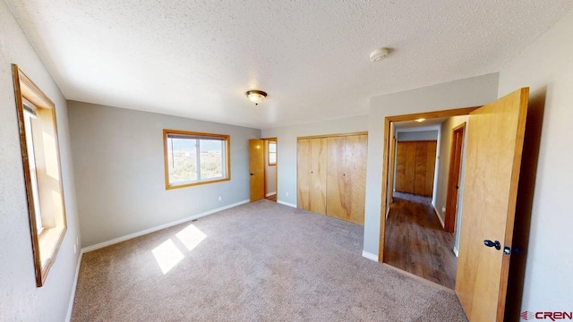 19029 Country Dr, Alamosa, CO 81101 - unfurnished bedroom featuring carpet floors, a textured ceiling, and a closet