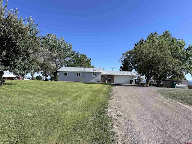 1885 Nichols Way, Montrose, CO 81401 - ranch-style house featuring dirt driveway, a front yard, a metal roof, and an attached garage