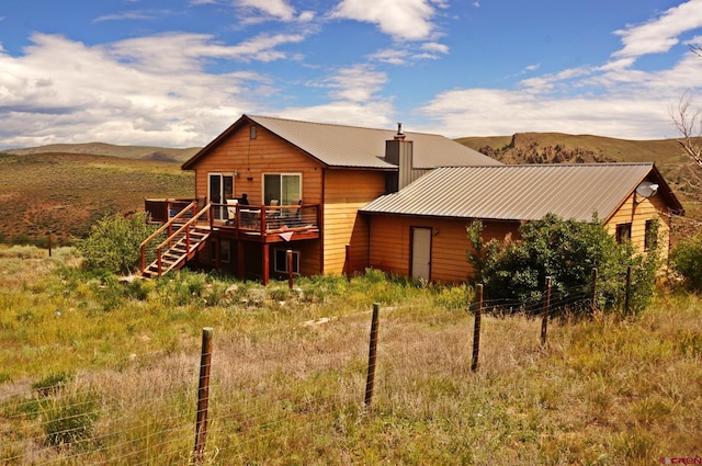 431 Antelope Rd, Gunnison, CO 81230 - back of property featuring a deck with mountain view, a metal roof, a chimney, and stairs