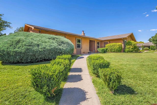 2909 Pheasant Run St, Grand Junction, CO 81506 - view of front facade featuring a front lawn and a chimney