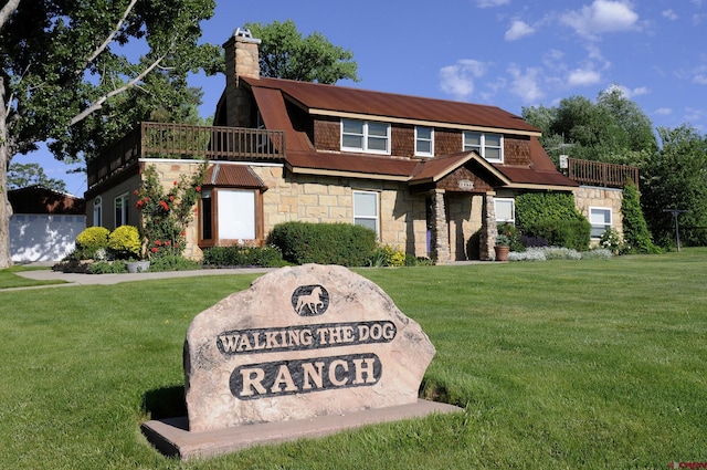 18173 Rd 22, Cortez, CO 81321 - view of front of property with stone siding, a chimney, a front yard, and a balcony