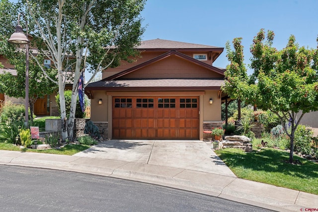 21 Tierra Verde Dr, Durango, CO 81301 - view of front of home featuring stone siding, concrete driveway, a shingled roof, and stucco siding