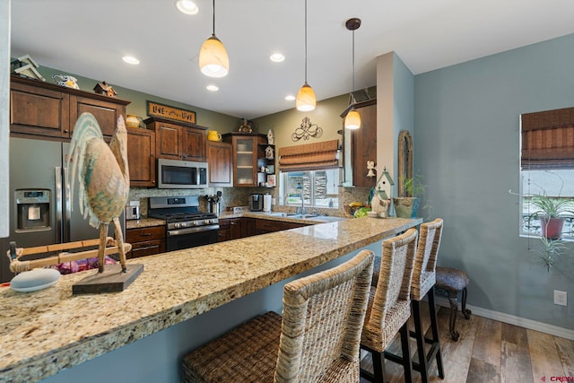 21 Tierra Verde Dr, Durango, CO 81301 - kitchen with appliances with stainless steel finishes, a kitchen breakfast bar, wood finished floors, pendant lighting, and recessed lighting