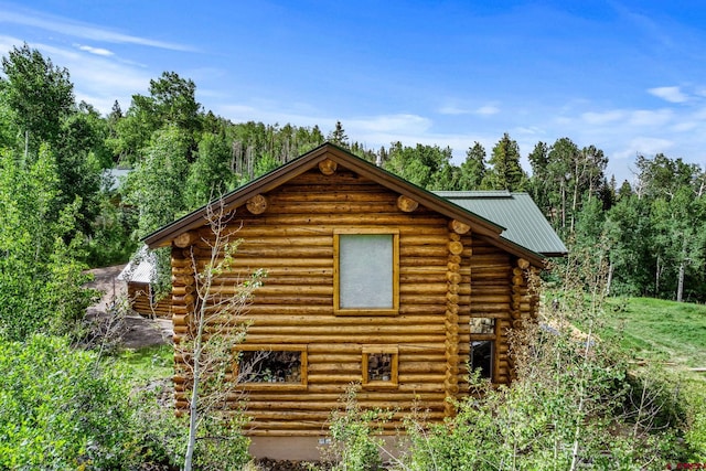 580 Lake Purgatory Dr, Durango, CO 81301 - view of side of home featuring log siding, a metal roof, and a wooded view