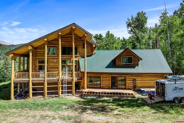 580 Lake Purgatory Dr, Durango, CO 81301 - view of front facade featuring log exterior, a deck with mountain view, and a metal roof