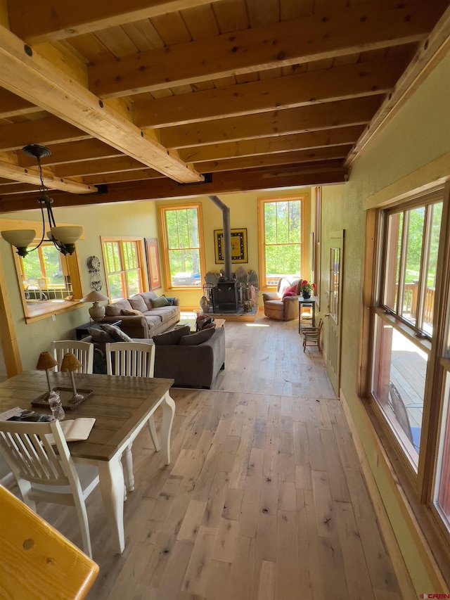 515 Bristol Rd, Placerville, CO 81430 - dining space with a wood stove, light wood-type flooring, healthy amount of natural light, and beam ceiling