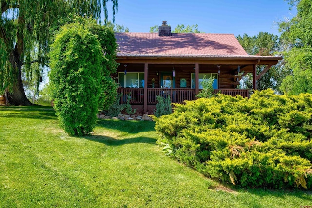 27126 Road R, Dolores, CO 81323 - view of front facade featuring a front lawn, a chimney, a metal roof, and log exterior