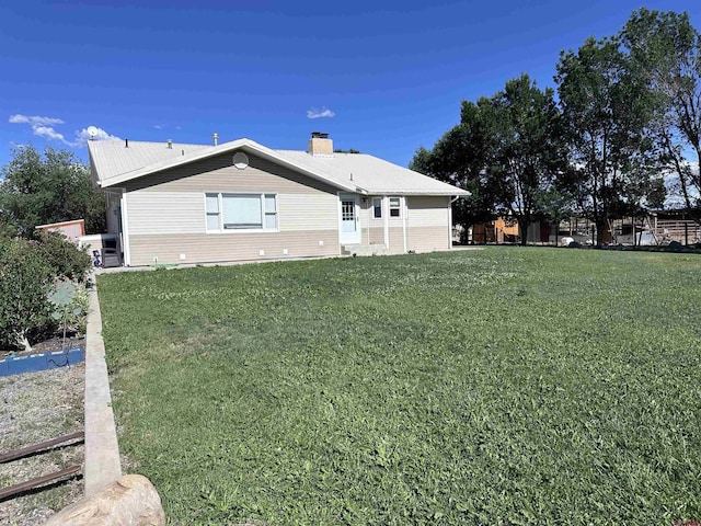 9456 6075th Rd, Montrose, CO 81403 - back of property featuring a chimney and a lawn