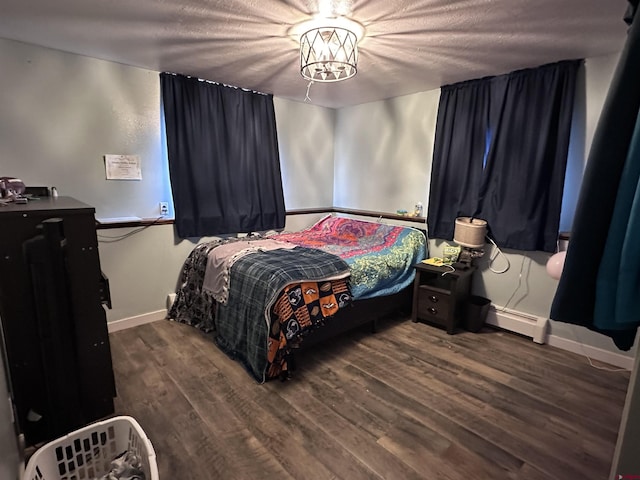 9456 6075th Rd, Montrose, CO 81403 - bedroom with baseboard heating, wood finished floors, and a textured ceiling