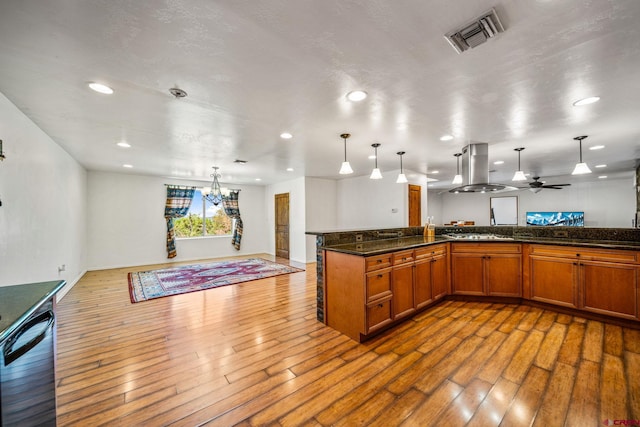 27420 Rd P.2, Dolores, CO 81323 - kitchen with island range hood, open floor plan, wood-type flooring, brown cabinetry, and black dishwasher